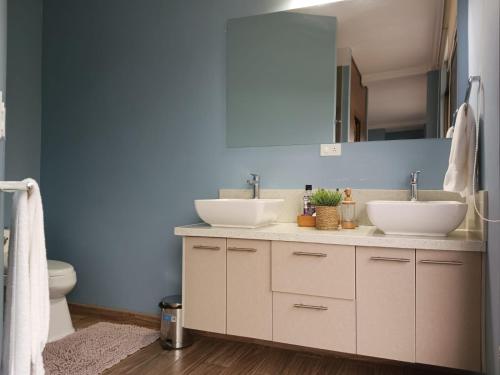 Łazienka z 2 umywalkami i niebieską ścianą w obiekcie BellaVista Casa de Montaña w mieście Latacunga