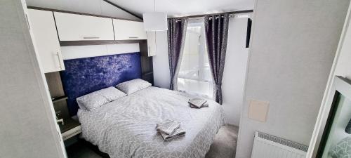 een kleine slaapkamer met een bed en een raam bij Luxury Lakefront Lodge 5 Star Country Park Huge Veranda Private Fishing Peg Near York FREE Parking in Malton
