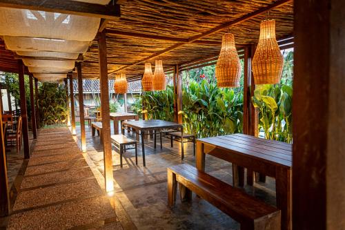 a row of tables and benches in a restaurant at Pousada O Canto do Francês in Soure