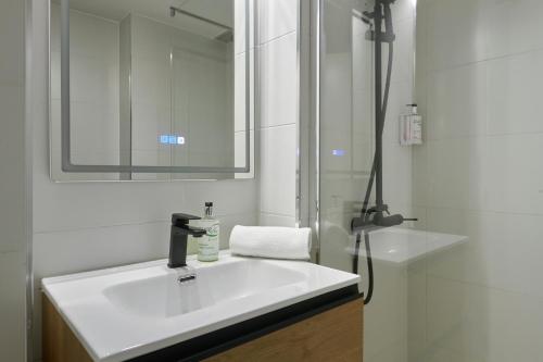 a bathroom with a white sink and a mirror at Ol Cute apartment in quiet Olivera st in Barcelona