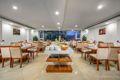 a dining room with a table and chairs and a room with tables and chairsktop at Prague Hotel in Da Nang