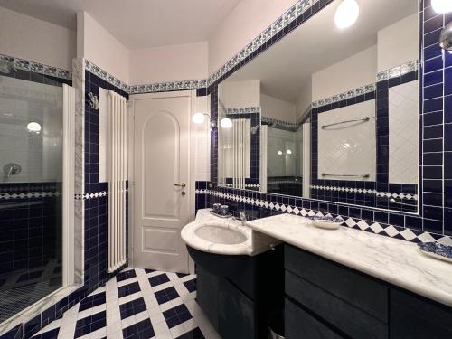 a blue and white bathroom with a sink and a shower at Villa Doria 16 Pax by VILLASRETREATS in Portovenere