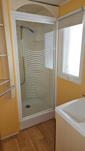 une douche en verre dans une salle de bain avec un lavabo dans l'établissement Mobilhome 573 camping 4* La Réserve 2 chambres, à Gastes
