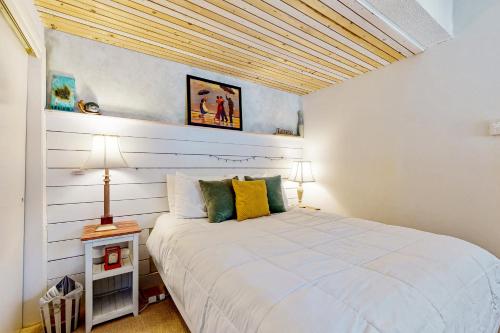 um quarto com uma cama branca e um tecto de madeira em The Mountain Sanctuary em Campton