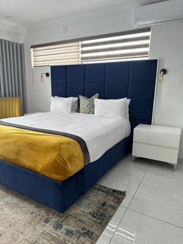 ein großes Bett mit blauem Kopfteil in einem Schlafzimmer in der Unterkunft Letaba Boutique Hotel and Spa in Giyani
