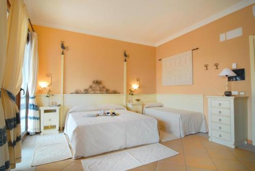 um quarto com 2 camas e paredes amarelas em Hotel La Rosa dei Venti em Buggerru