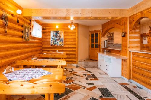 a kitchen and dining room with wooden walls and tables at Pokoje Gościnne Aniela Stasik in Gliczarów Górny