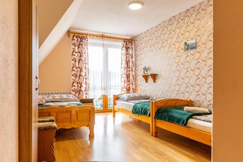 a bedroom with two beds and a window at Pokoje Gościnne Aniela Stasik in Gliczarów Górny