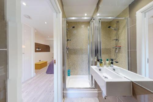 y baño con lavabo blanco y ducha. en Hampstead 4-bedrooms condo apartment en Londres