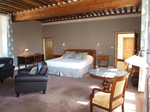 um quarto com uma cama, uma mesa e cadeiras em La Grande Ferme Maison de Maître em Crépon