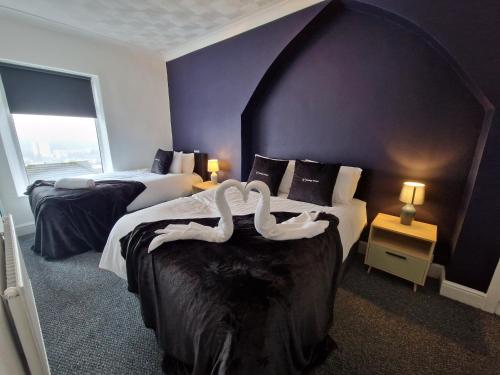 Una habitación de hotel con dos camas con cisnes. en Oasis 3 Bedroom Home Near Town Centre with garage for bike storage, en Dowlais