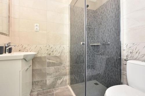 e bagno con doccia, servizi igienici e lavandino. di Apartments with private pool a Trogir
