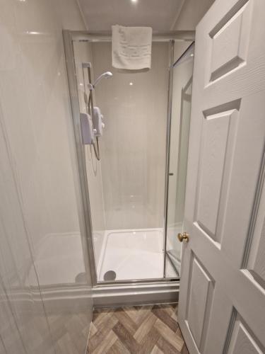 y baño con ducha y puerta de cristal. en Oasis 3 Bedroom Home Near Town Centre with garage for bike storage, en Dowlais