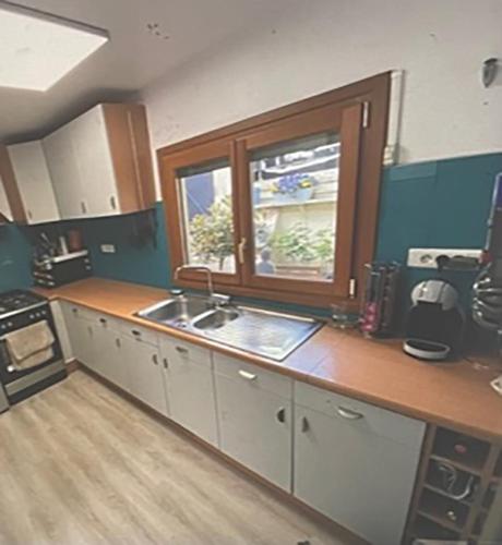 une cuisine avec un évier et une fenêtre dans l'établissement Amienoise centre ville, à Amiens