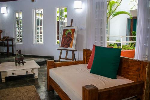 Habitación con una cama con una pintura y una mesa en pousada da sarafina ltda en Salvador