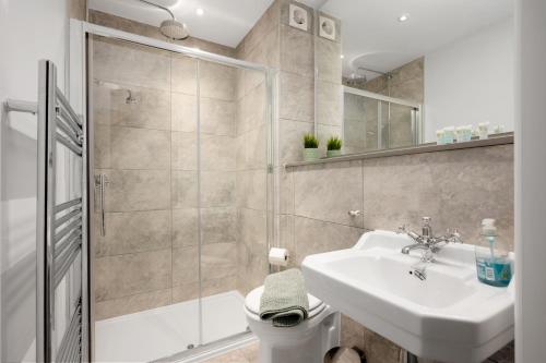 a bathroom with a shower and a sink and a toilet at 316 Reids Corner - by StayDunfermline in Dunfermline