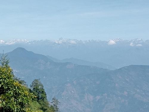 a view of a mountain range with snow capped mountains at Diksha Homestay in Darjeeling