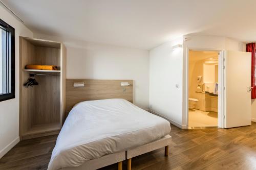 a small bedroom with a bed and a bathroom at Hotel du Parc - Chantepie in Chantepie