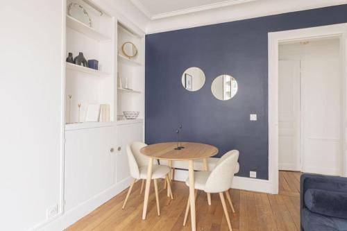 une salle à manger avec une table et des chaises blanches dans l'établissement Apartment 1 Bedroom # Paris 14 # Alesia, à Paris