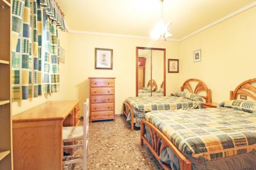 1 dormitorio con 2 camas, escritorio y tocador en Global Properties, Piso centrico en Puerto de Sagunto y comodo en Puerto de Sagunto