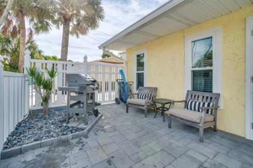 a patio with two chairs and a grill on a house at Relax Just Steps to the Soft White Sandy Beach, Heated Pool in Holmes Beach