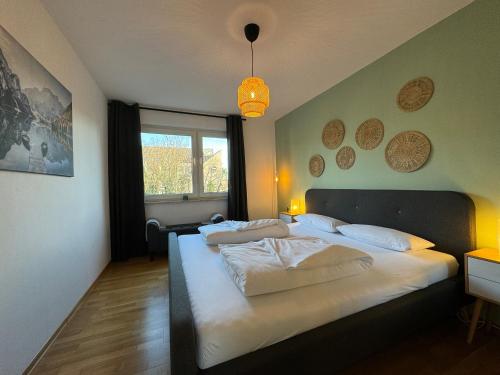ein Schlafzimmer mit einem großen Bett mit weißer Bettwäsche in der Unterkunft Zentrales 2-Zi Apartment by Rabe - Kirche - Coffee-Bar in Karlsruhe