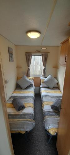 a small room with three beds and a window at Yarborough View 1 Whitecliff Bay Bembridge Isle of Wight in Bembridge