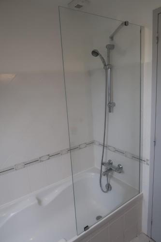 a shower with a glass door next to a bath tub at Maison à 200m des plages de Brignogan - Holiday Home-Fereinhaus in Brignogan-Plages