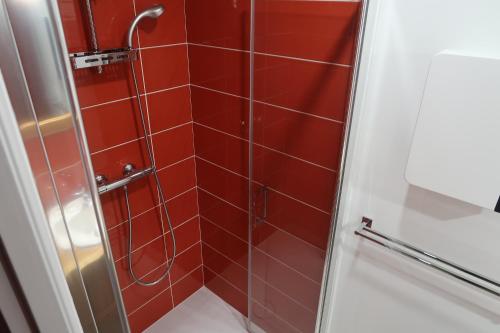 a shower with red tiles in a bathroom at Maison à 200m des plages de Brignogan - Holiday Home-Fereinhaus in Brignogan-Plages