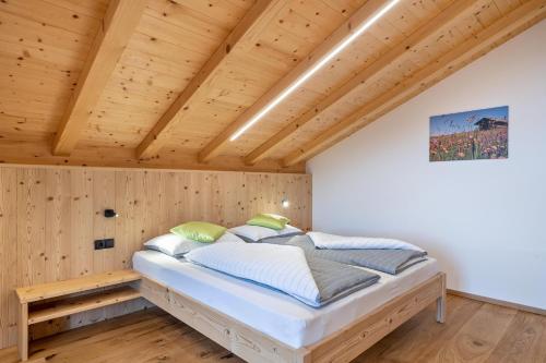 a bedroom with a bed in a room with wooden walls at Parliflhof Apt Laugenblick in Meltina