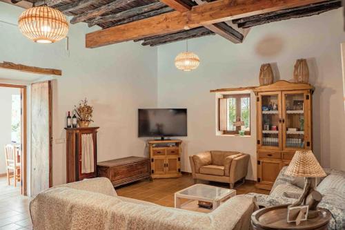 sala de estar con sofá y TV en Charming Ibiza villa, en Sant Llorenç de Balàfia