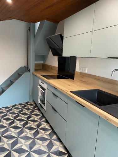 Una cocina con gabinetes blancos y un fregadero. en Maison Curières, en Curières