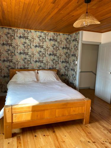 - un lit en bois dans une chambre avec un mur dans l'établissement Maison Curières, à Curières