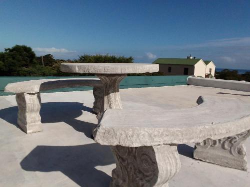 two stone benches sitting on top of a patio at Streams Cottage in Bettyʼs Bay