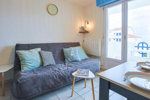 un salon avec un canapé en cuir et une table dans l'établissement Apt vue mer - balcon - parking, à Les Sables-dʼOlonne