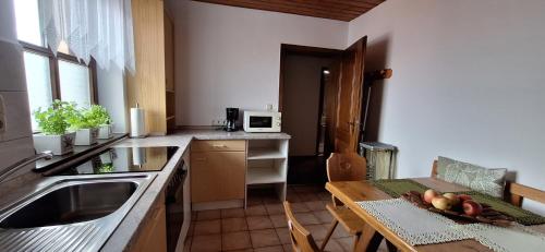 a kitchen with a sink and a table with fruit on it at Ferienhaus Resch in Laufen
