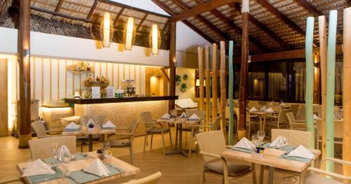 a dining room with tables and chairs and chandeliers at Vista Sol Punta Cana Beach Resort & Spa - All Inclusive in Punta Cana