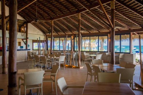 a restaurant with tables and chairs and the ocean at Vista Sol Punta Cana Beach Resort & Spa - All Inclusive in Punta Cana