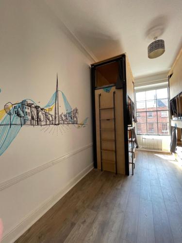 una habitación con una puerta con una pintura en la pared en Leevin Hostel George, en Dublín
