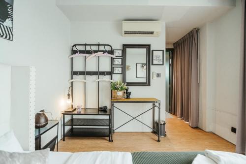 - une chambre avec un lit, une table et un miroir dans l'établissement พูลวิลล่ากรุงเทพ, à Bangna