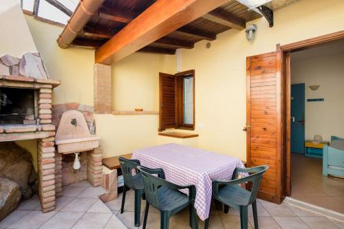 a dining room with a table and chairs and a fireplace at Villetta Celeste - vista mare a 80metri dalla spiaggia in Geremèas