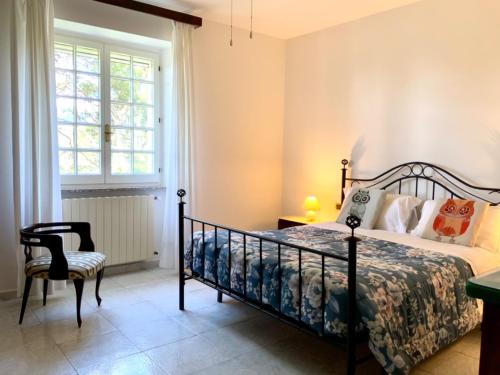 um quarto com uma cama, uma cadeira e uma janela em Aragonite Azzurra Casa Vacanza em Gonnesa