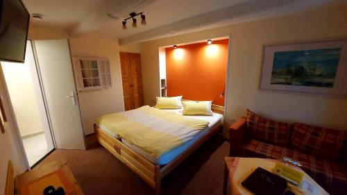 ein kleines Schlafzimmer mit einem Bett und einem Sofa in der Unterkunft Hotel garni & Oma's Heuhotel 'Pension zur Galerie' in Barby