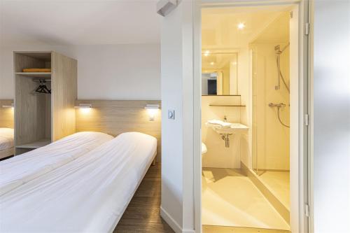 een slaapkamer met een bed en een badkamer met een wastafel bij Hotel du Parc - Chantepie in Chantepie