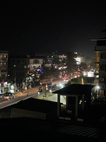 uma cidade à noite com luzes numa rua em Shyama tara em Panchanai