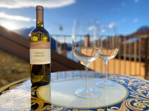 una bottiglia di vino e due bicchieri di vino su un tavolo di CHIAVE DI VOLTA Lovely Guesthouse with Terrace a Varenna
