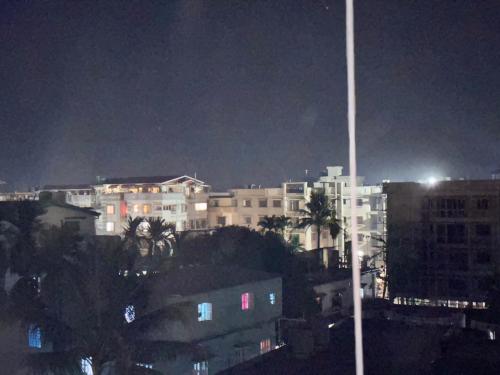 uma cidade à noite com edifícios e uma luz de rua em Shyama tara em Panchanai