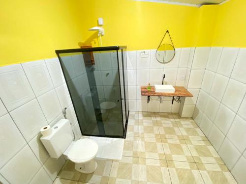 La salle de bains est pourvue de toilettes, d'une douche et d'un lavabo. dans l'établissement Pousada Jardim Lençóis, à Lençóis