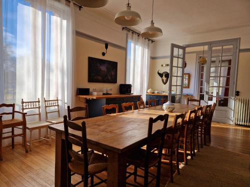 a dining room with a large wooden table and chairs at HOTEL DE L'ABBAYE DE LONGPONT in Longpont