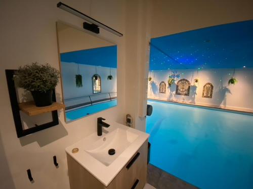 a bathroom with a sink and a large mirror at B&B Wellness Soest in Soest